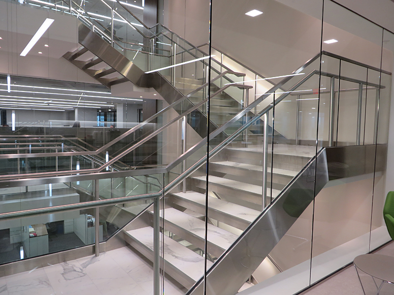 Decorative metal stair featuring illuminated stainless steel handrail.