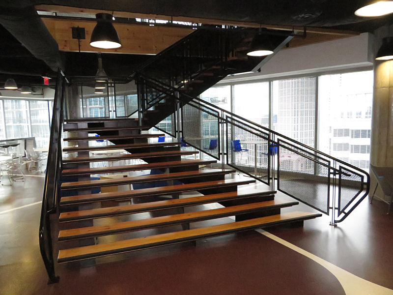 Cantilevered decorative metal stair with wood treads