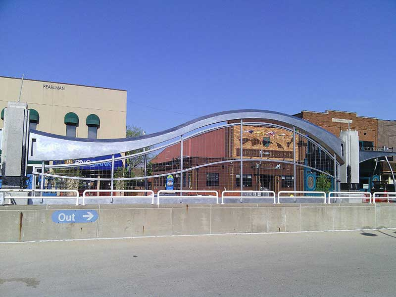 Sixty foot long stainless steel sculpture with lighted trellis beneath at the City of Battle Creek. Fabricated by Couturier Iron Craft and Hoffman Bros. Construction