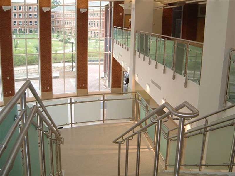 Staircase with fabricated stainless steel railings with frosted glass