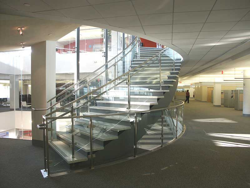 Curved multi flight decorative staircase with glass and stainless steel railings.