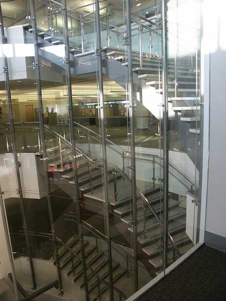 Curved stairway separated by glass wall.