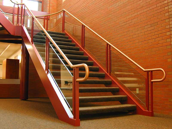Decorative stair with custom brass and glass rails.