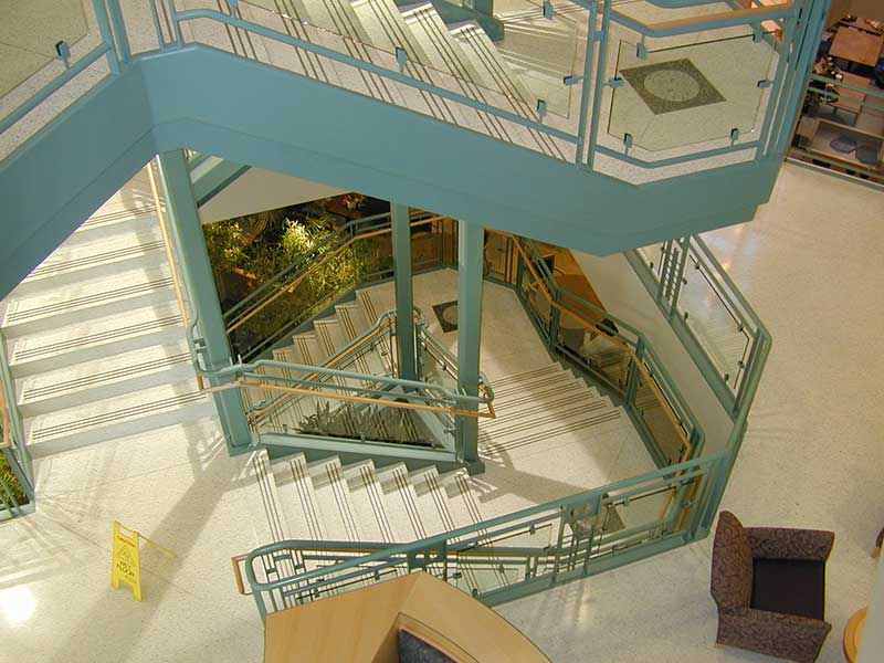 Beautiful ornamental stair with glass and wood handrail.