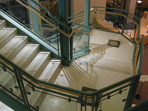 Green painted stairway with ornamental glass rails.